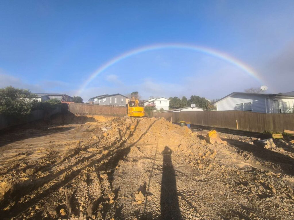 Excavated building site with trench and excavator