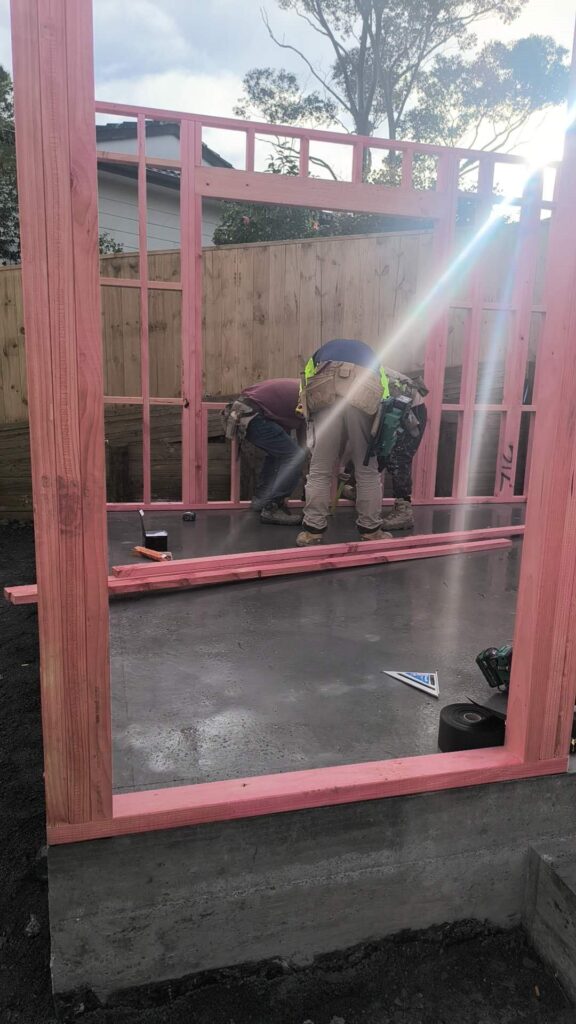 Workers erecting a timber wall frame