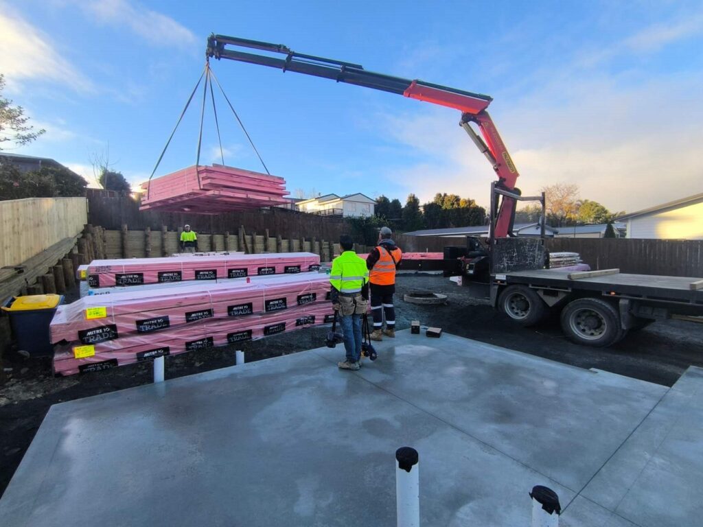 Crane lifting timber frames on site
